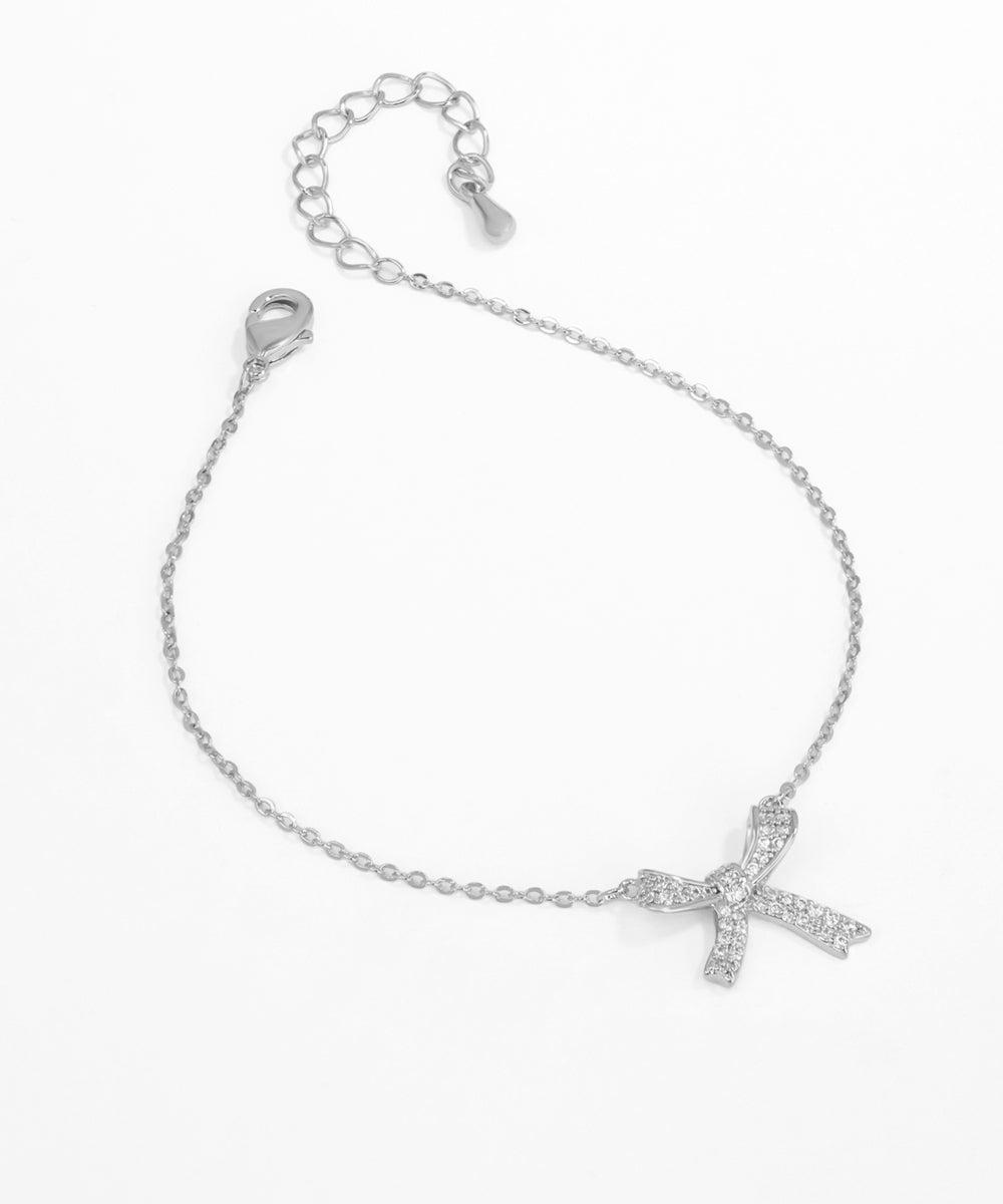 Silver bracelet with a cross charm on a white background