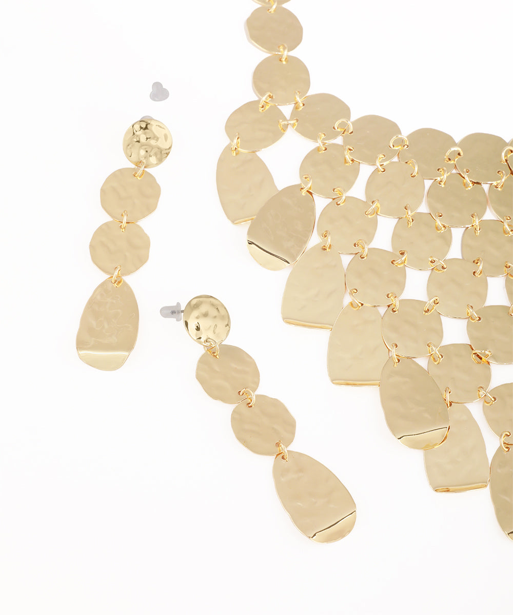Gold earrings with circular and teardrop shapes on a white background