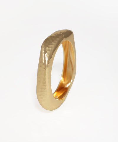 Gold ring with a textured surface on a white background