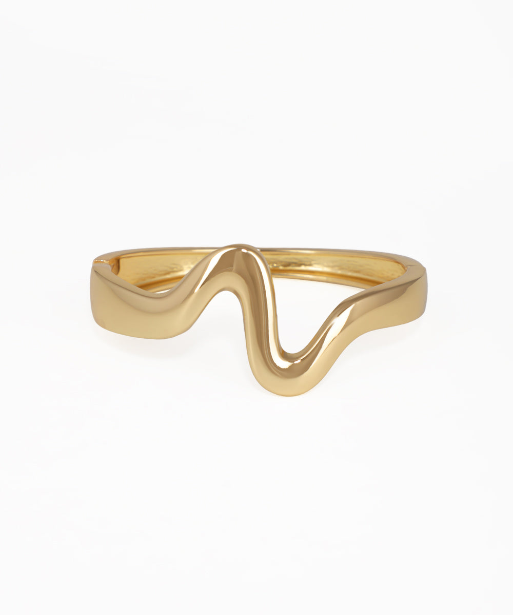 Gold ring with a wavy design on a white background