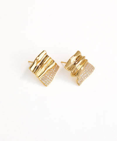 Gold earrings with a textured design on a white background