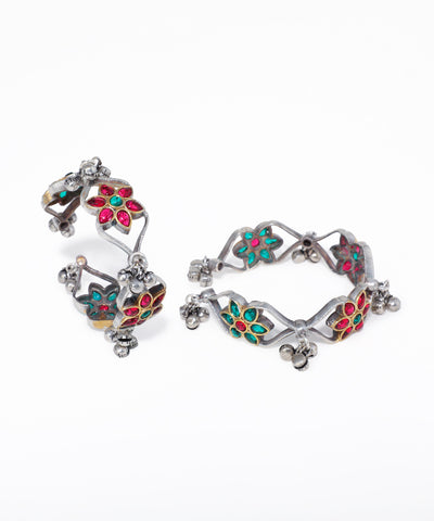 Pair of silver earrings with colorful gemstones on a white background