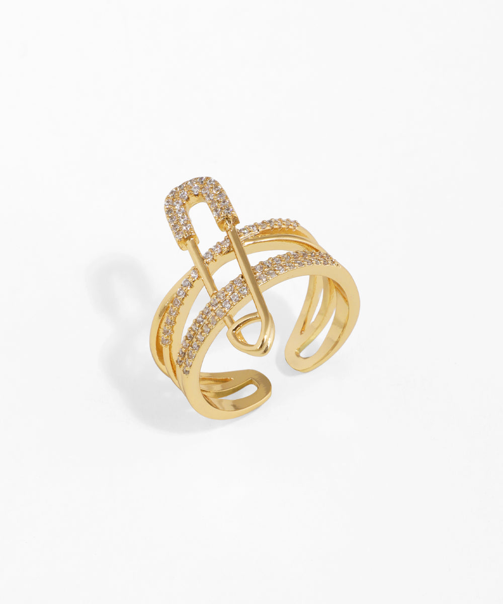 Gold-tone adjustable ring with crisscross bands and sparkle-set safety pin detail