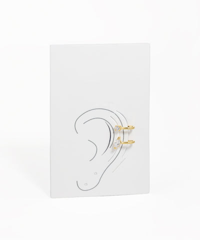 Earring display card with ear illustration and gold earrings on a white background