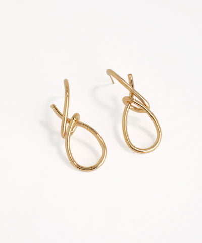 Gold hoop type earrings on a white background
