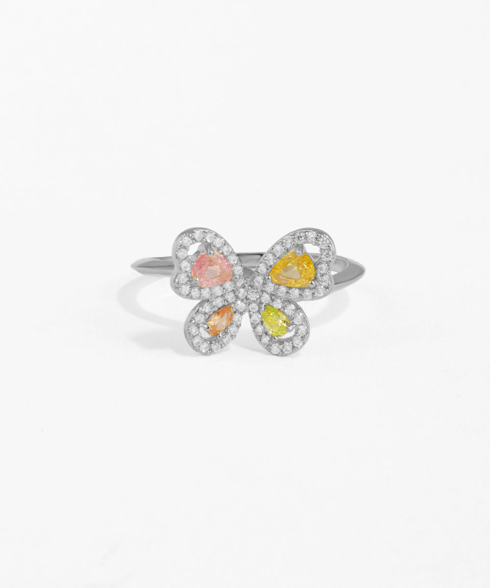 Flower-shaped ring with colorful stones on a white background