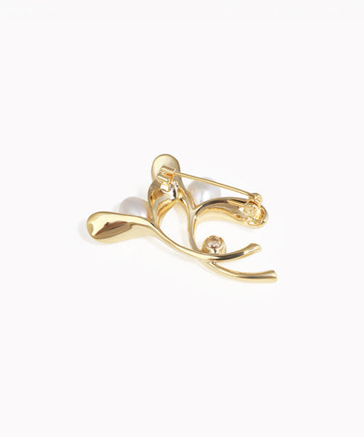 Gold earring with a pearl on a white background