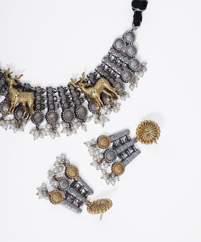 Ornate necklace with deer figures and matching earrings on a white background