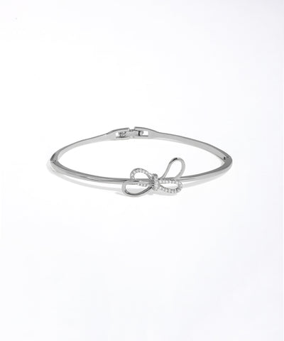 Silver bracelet with bow design on a white background