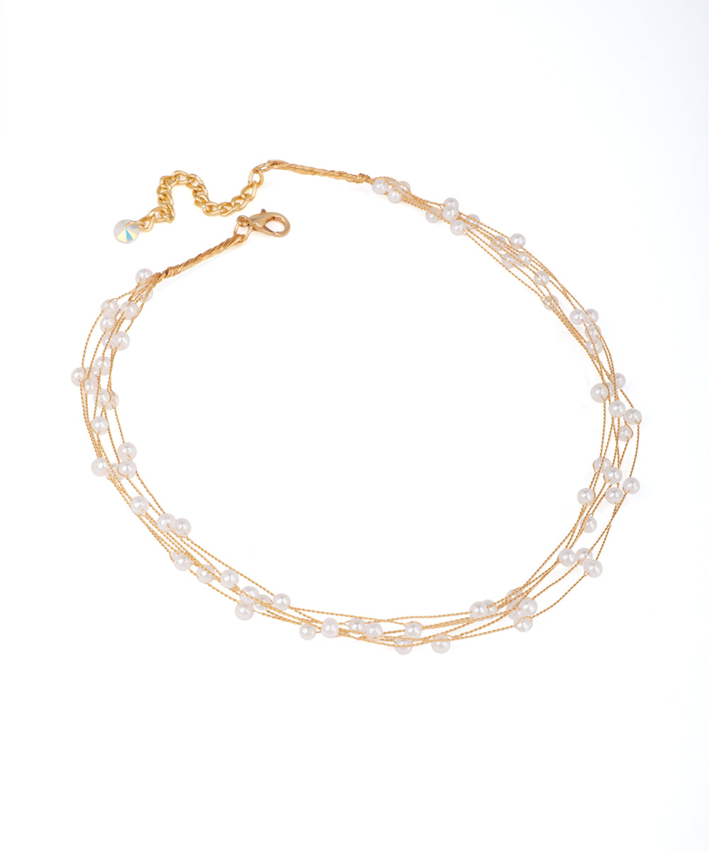 Gold-tone necklace with multiple fine strands and scattered white faux pearls, featuring an adjustable clasp.