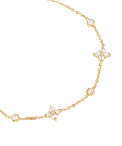 Gold necklace with diamond accents on a white background