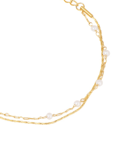 Gold chain necklace with pearls on a white background