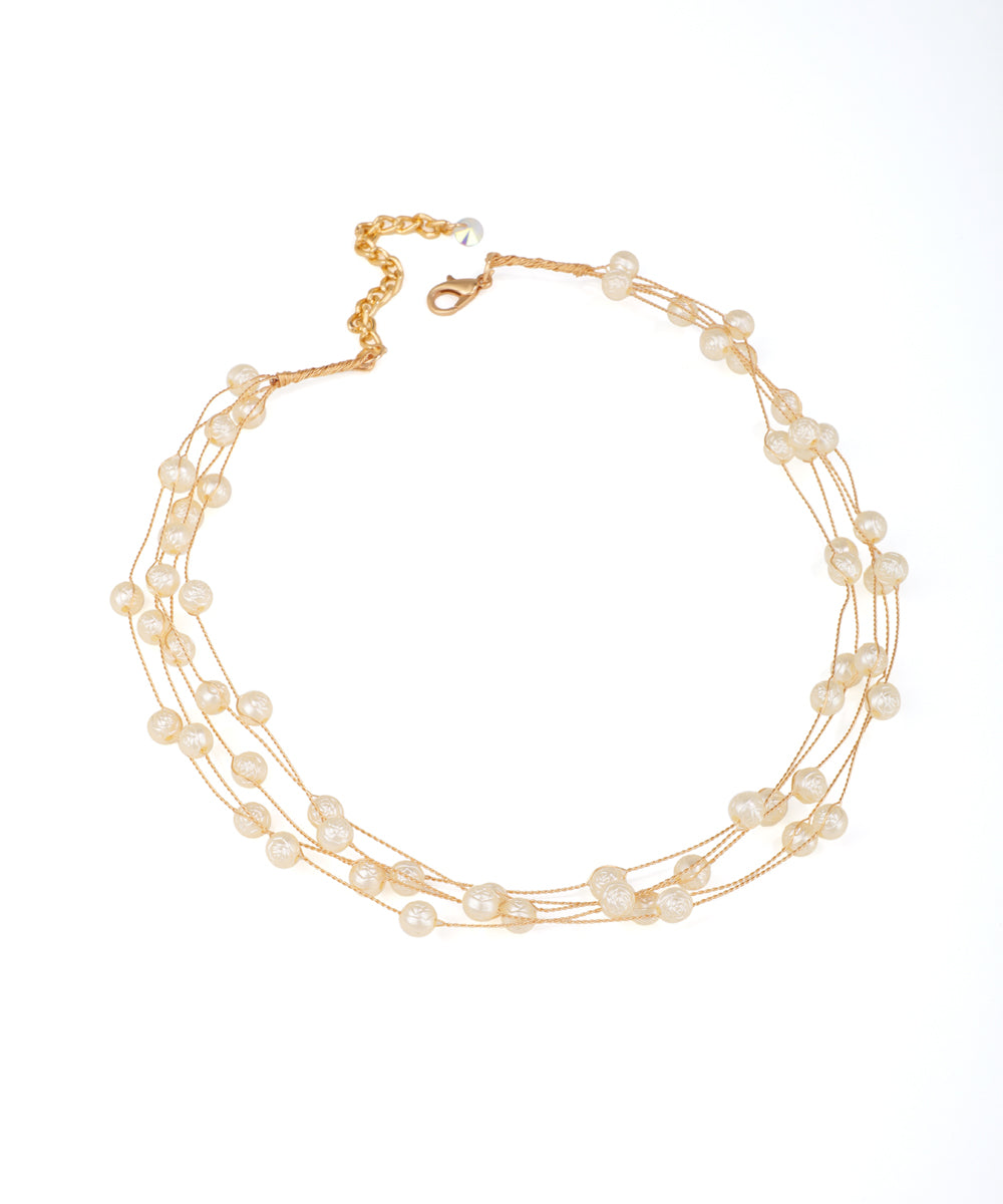 Gold-tone multi-strand necklace with delicate faux pearls and adjustable lobster clasp
