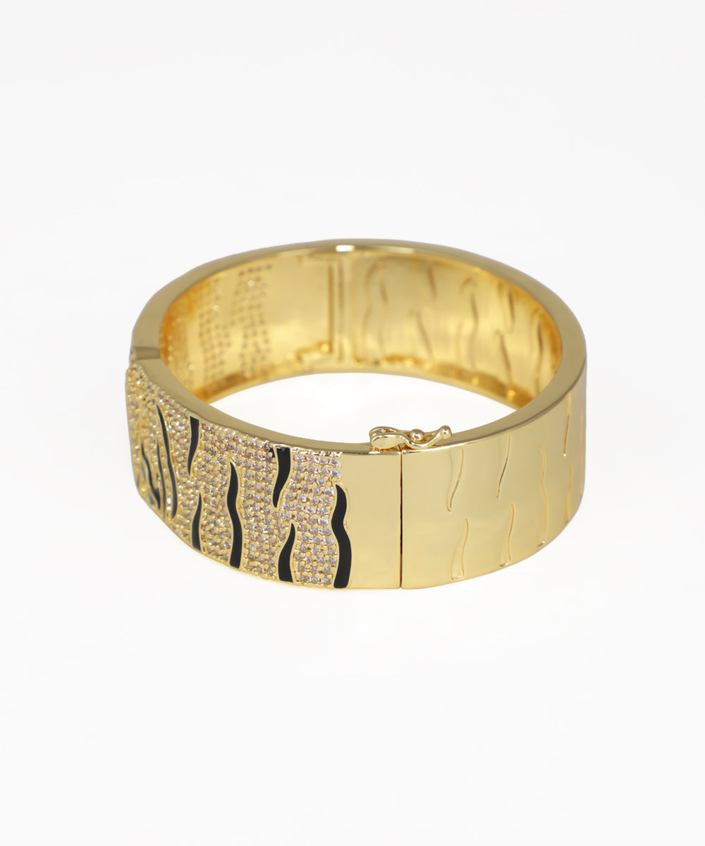 Gold bracelet with zebra pattern on a white background