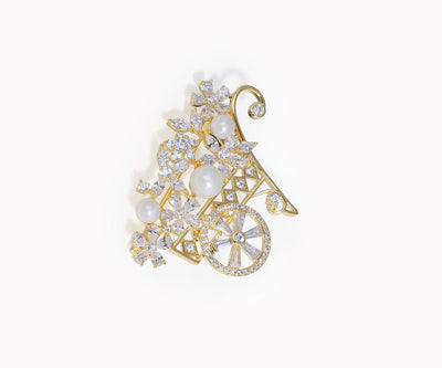 Gold brooch with pearls and crystals on a white background