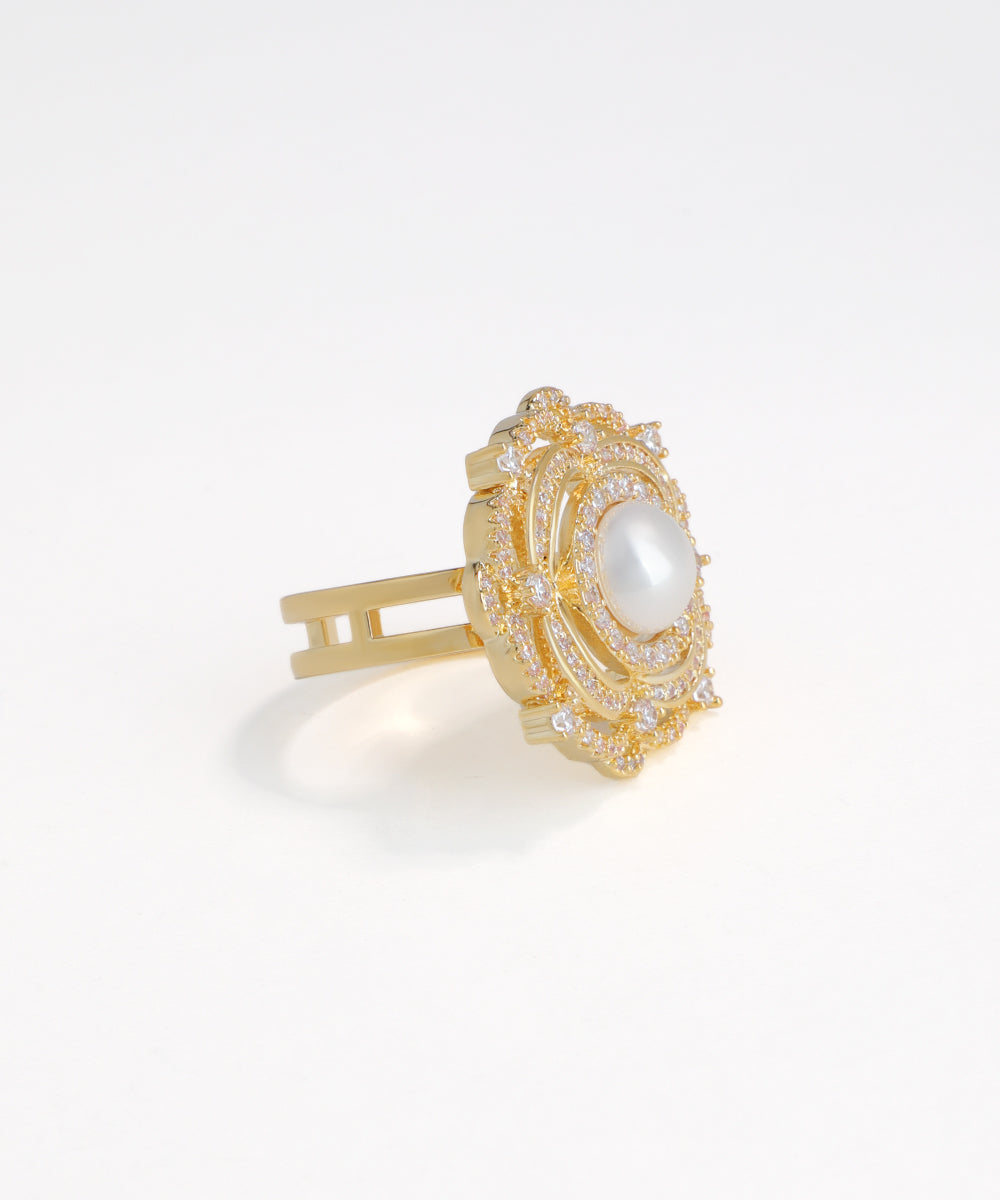 Gold hair clip with a central pearl on a white background