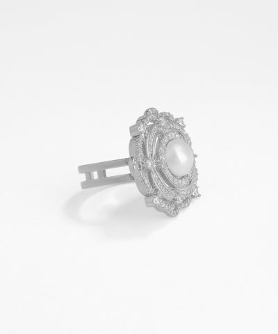 Silver hair clip with a central pearl on a white background