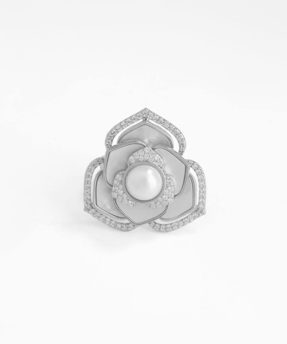 Silver flower-shaped earring with pearl center on a white background