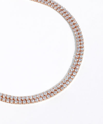 Rose gold necklace with clear gemstones on a white background