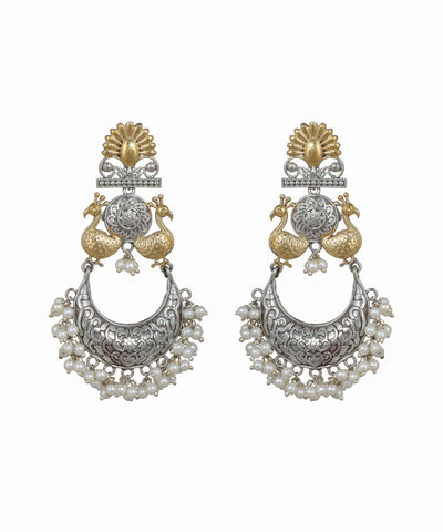Pair of ornate earrings with gold and silver design on a white background