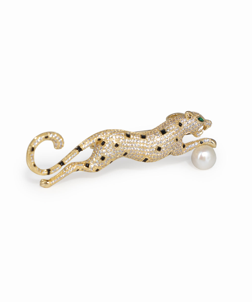 Gold-tone leaping panther brooch pin with clear and black CZ stones, green glass eyes, and a faux pearl