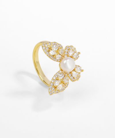 Gold ring with pearl and crystals on a white background