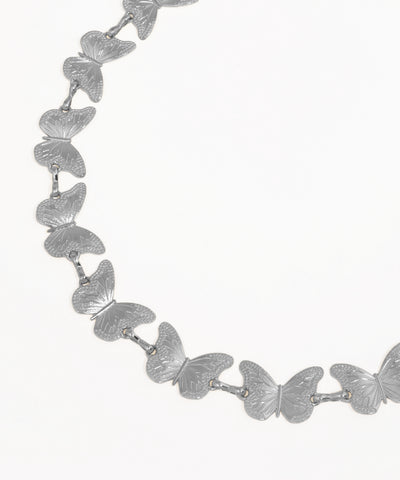Silver butterfly necklace on a white background