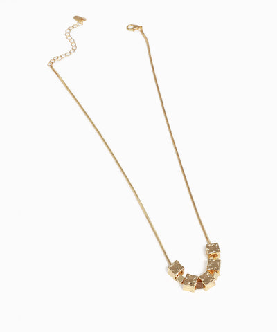 Gold-tone snake chain necklace with seven textured hammered cube beads.