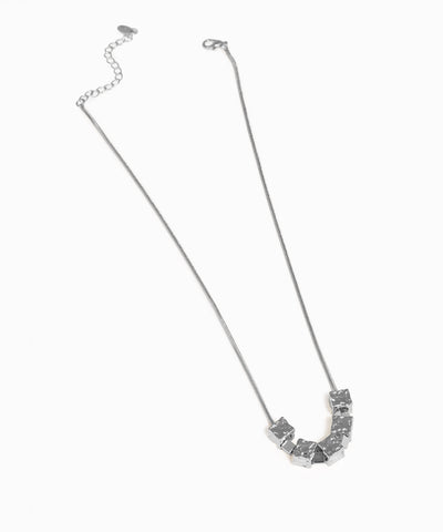 Silver necklace with geometric pendants on a white background