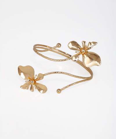 Gold-tone arm cuff with two sculpted floral motifs and a coiled vine design.