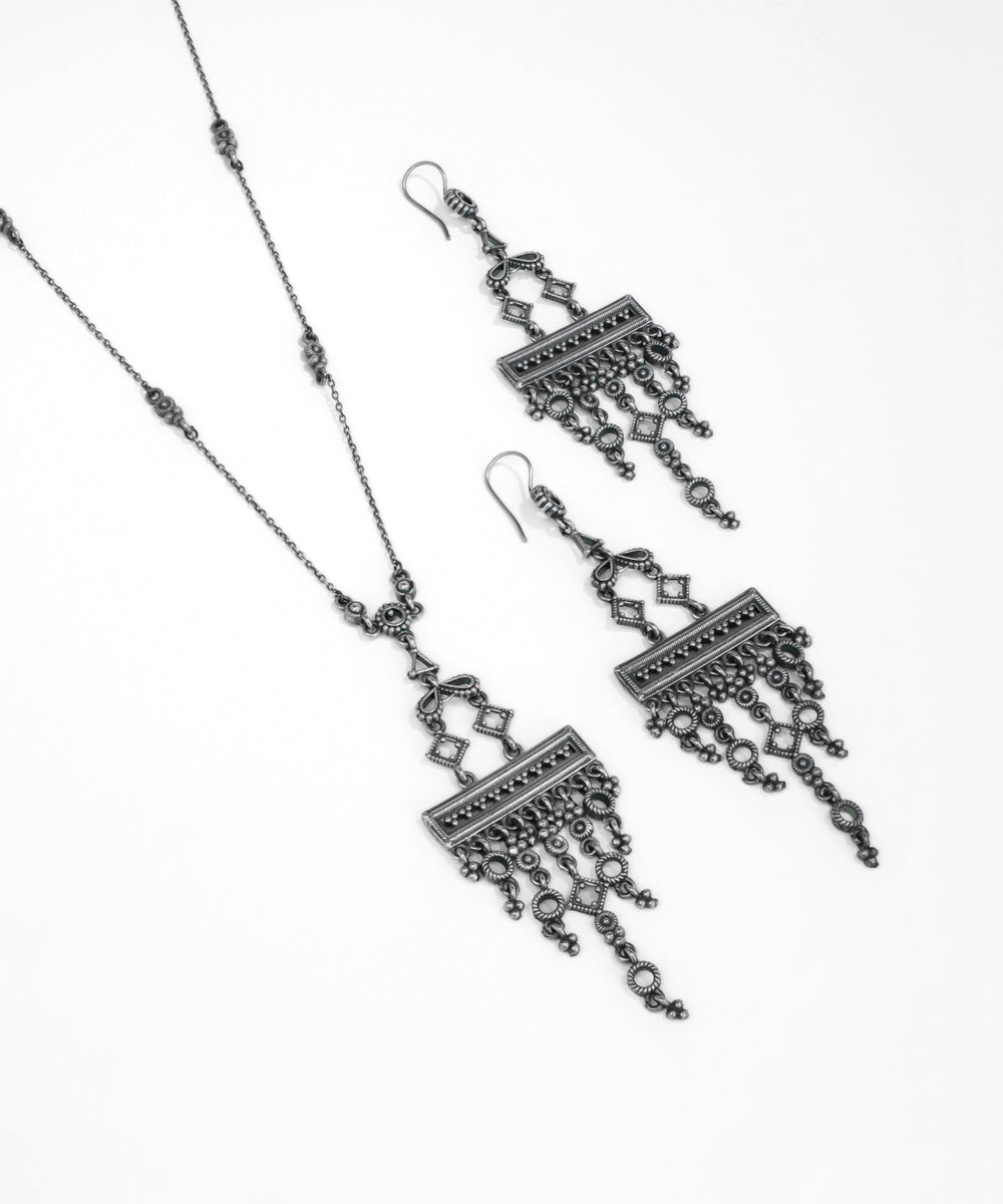 Pair of silver earrings with intricate designs on a white background