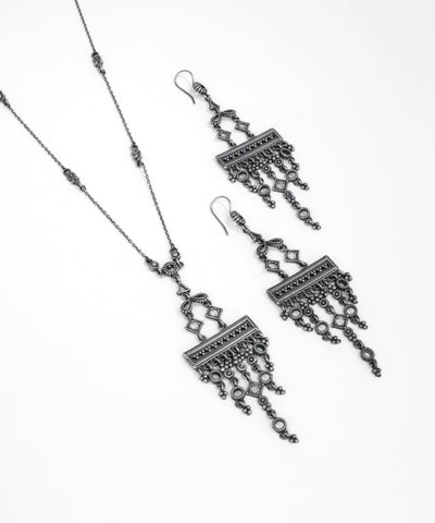 Pair of silver earrings with intricate designs on a white background