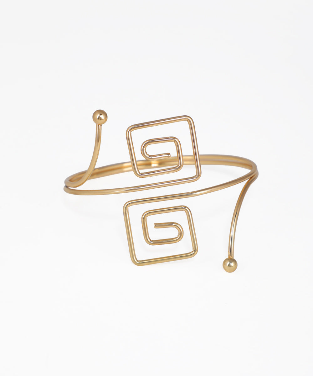 Gold-tone arm cuff with open-ended design and two square spiral motifs