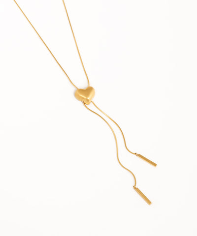 Gold necklace with a heart-shaped pendant on a white background