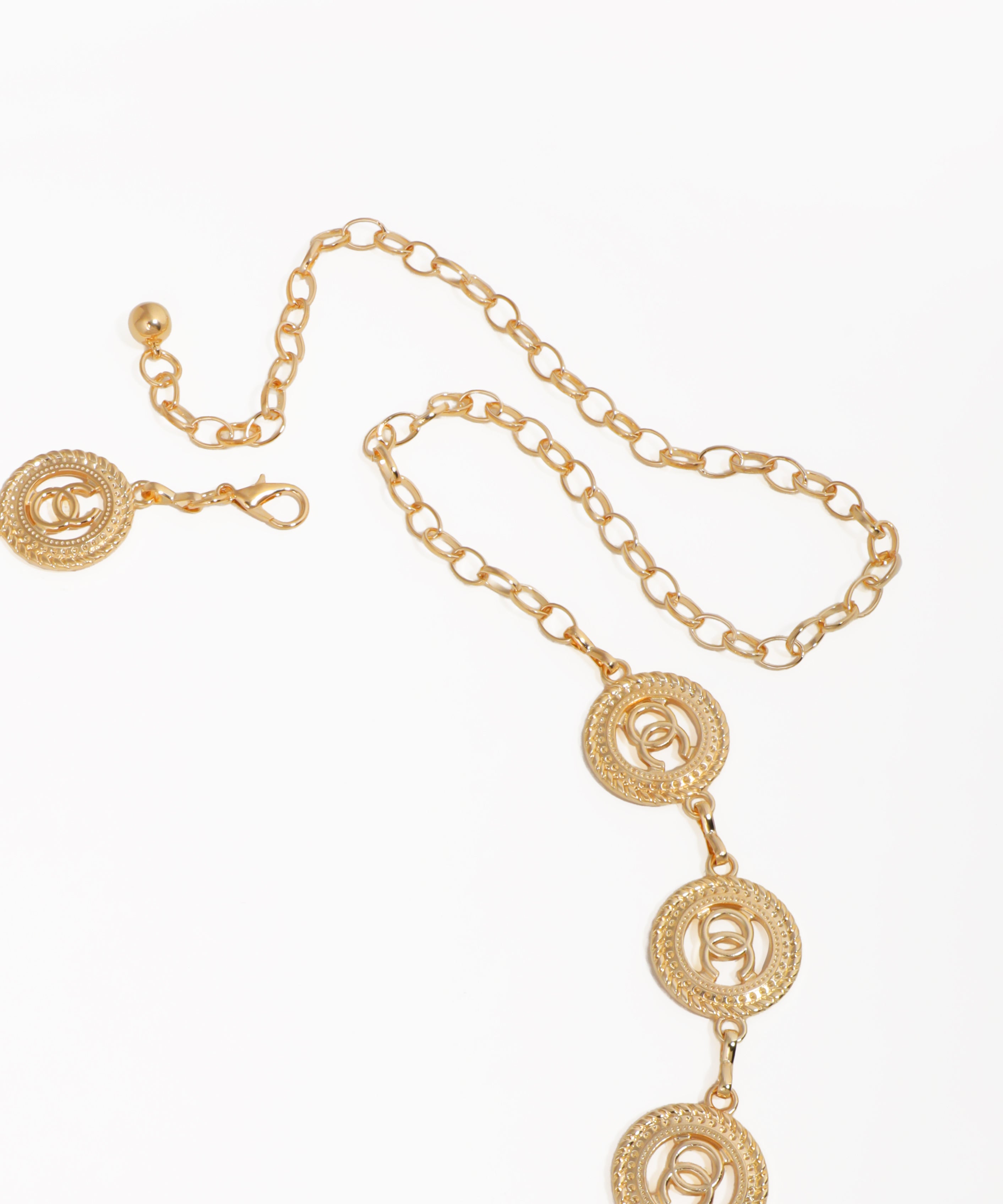 Gold necklace with circular pendants on a white background