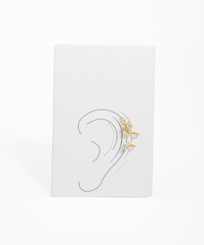 Earring display with gold earrings on a white background