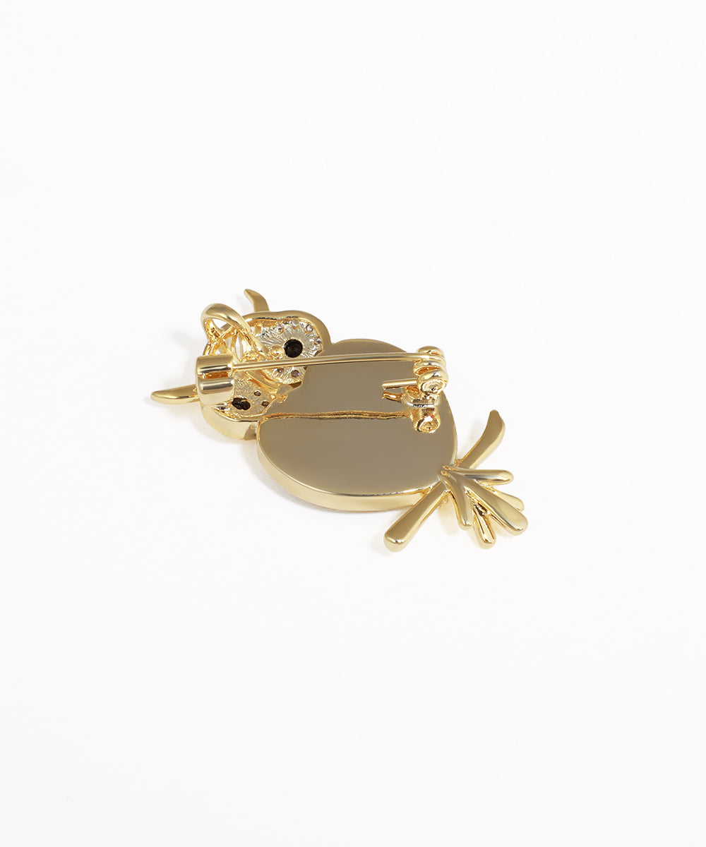 Gold owl-shaped brooch on a white background