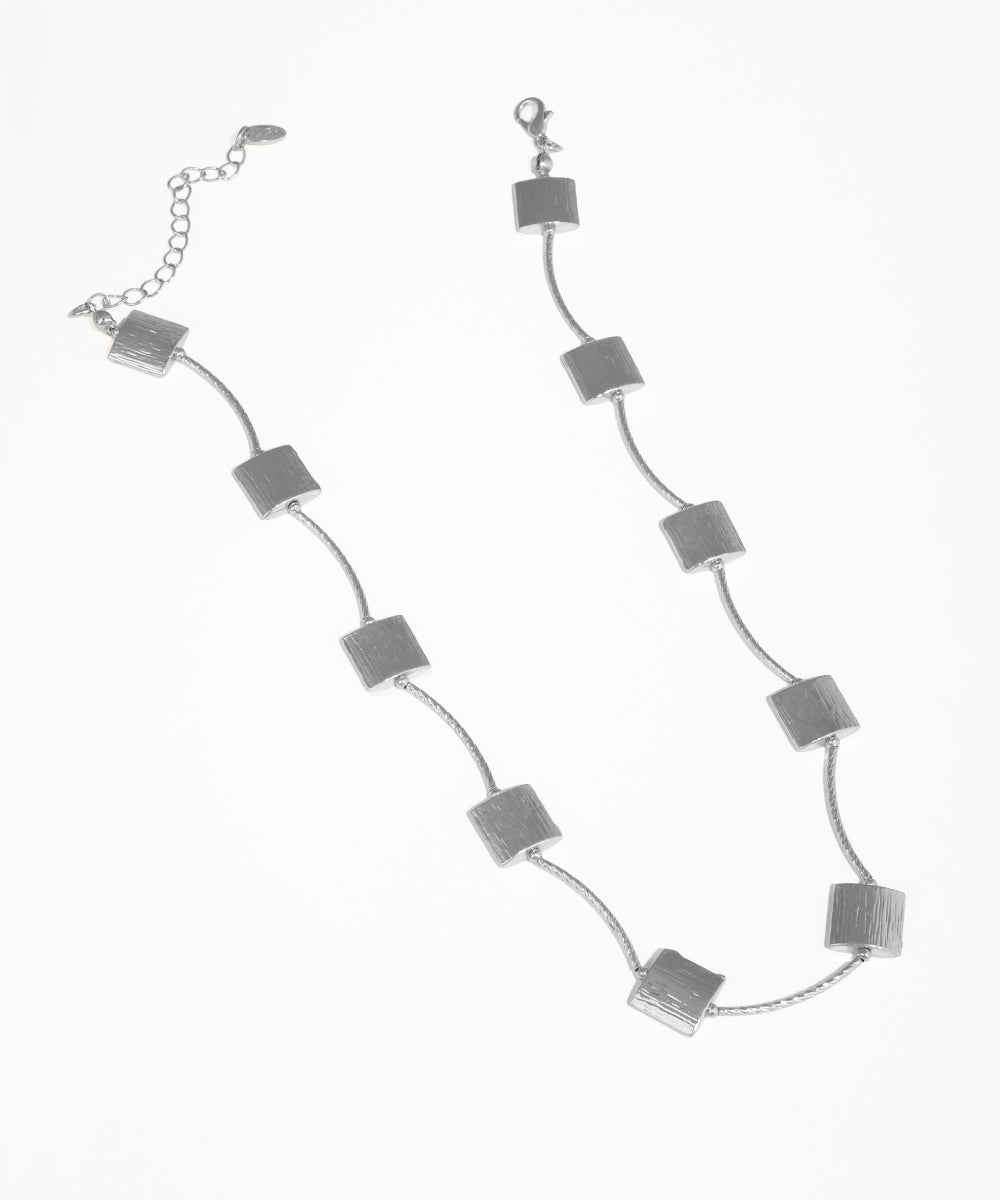 Silver necklace with square pendants on a white background