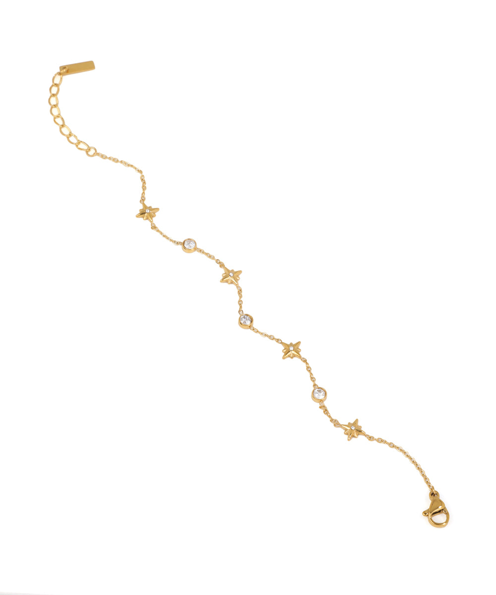 Gold bracelet with star and diamond accents on a white background