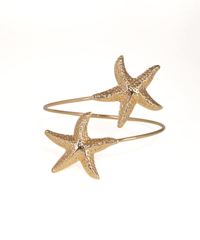 Gold starfish-shaped cuff bracelet on a white background