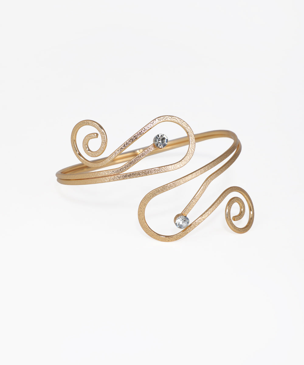 Gold-tone arm cuff with sculptural swirl design and two clear stones