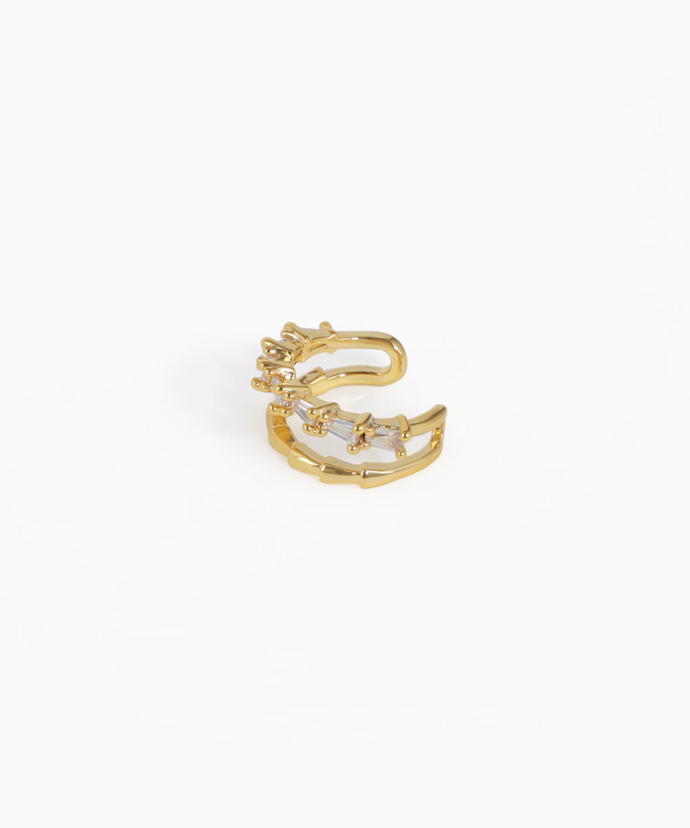 Gold ring with star and moon designs on a white background