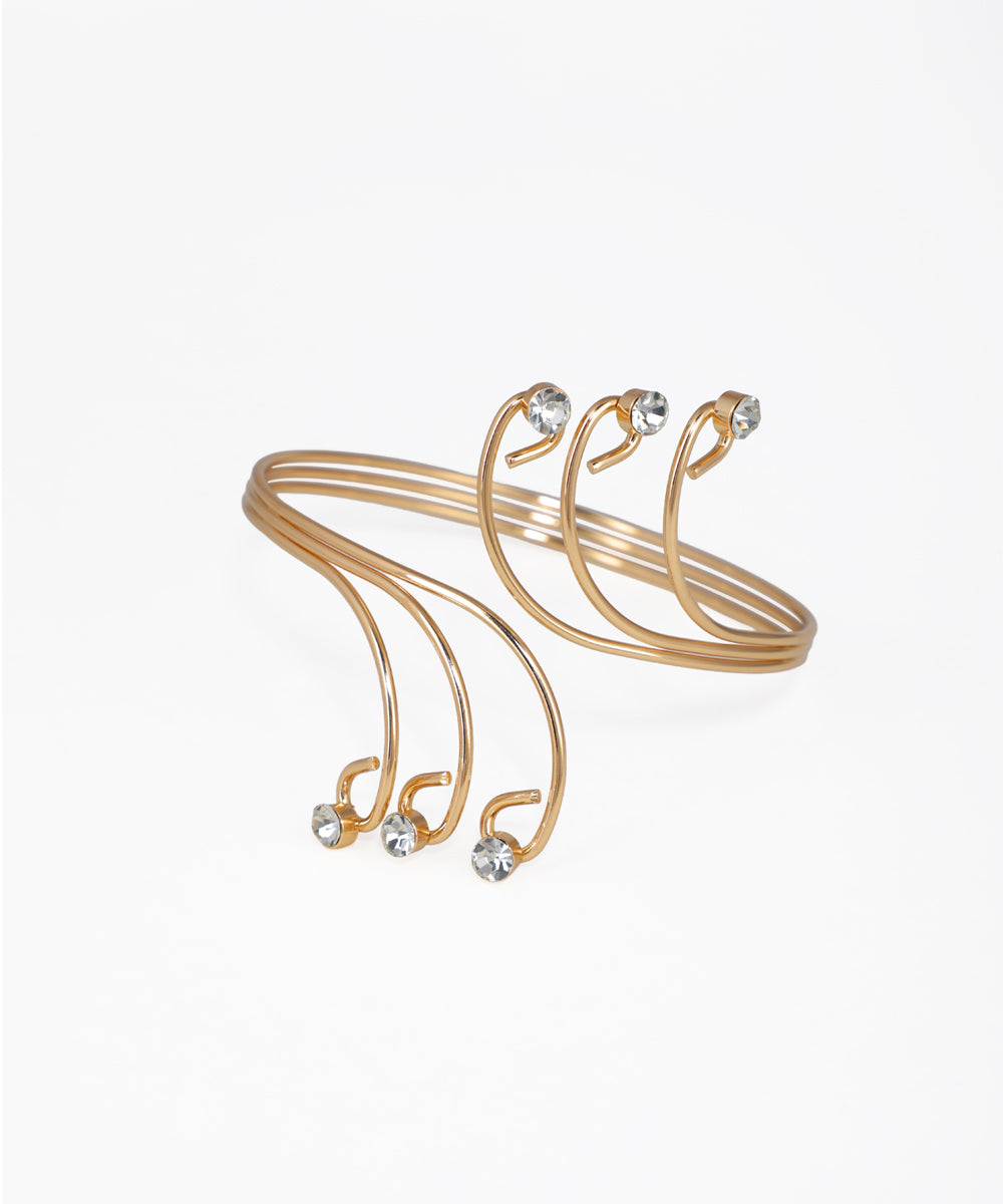 Gold-tone arm cuff with swirling wire design and clear stone accents