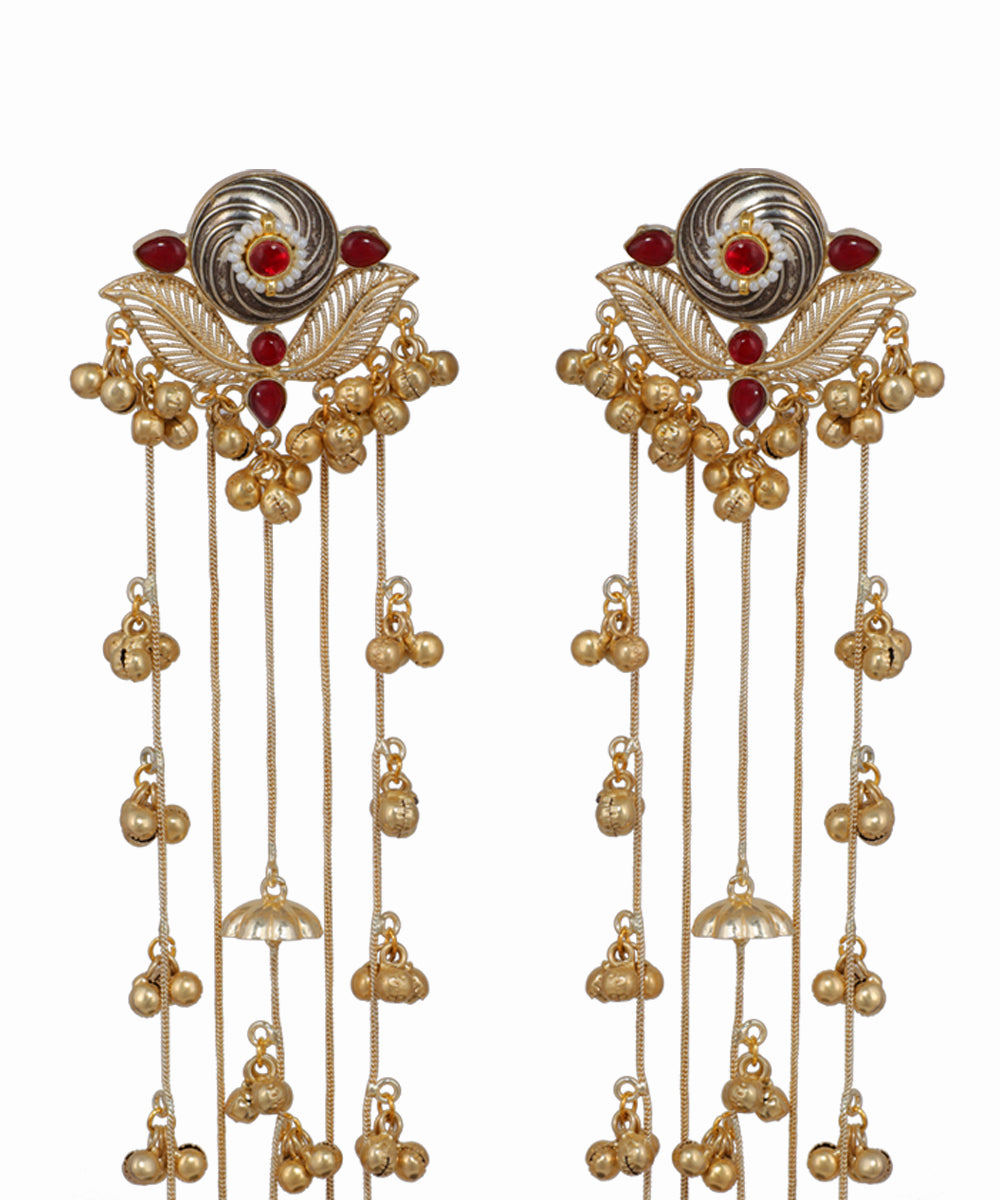 Pair of ornate earrings with gold and red accents on a white background