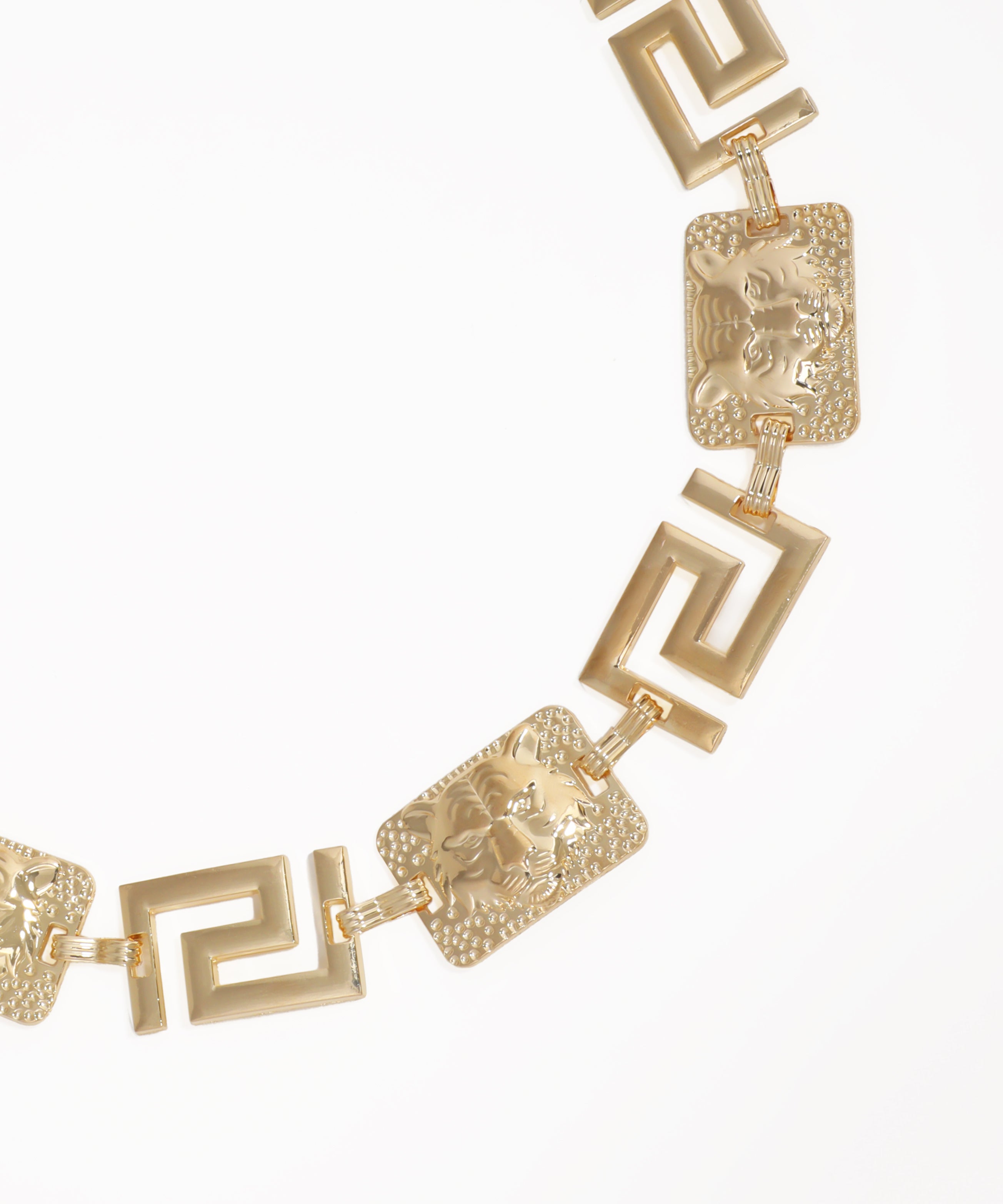 Gold necklace with intricate designs on a white background