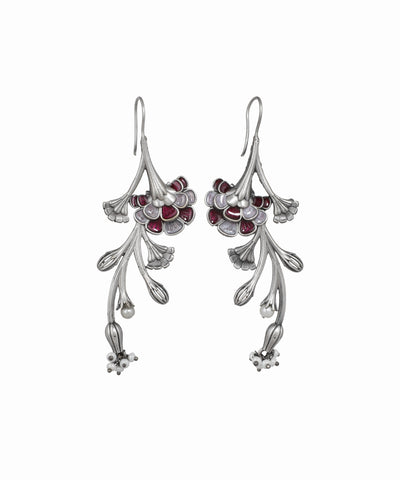 Silver floral earrings with red gemstones on a white background
