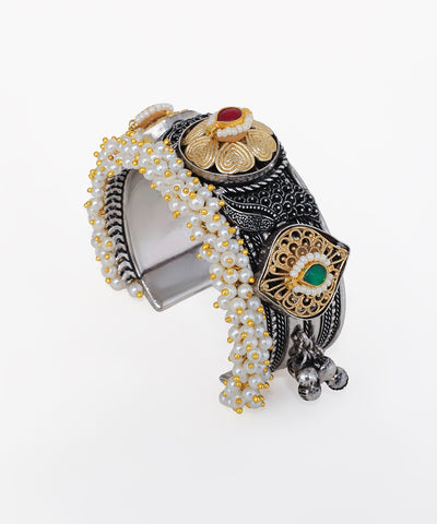 Decorative bracelet with beads and metallic elements on a white background