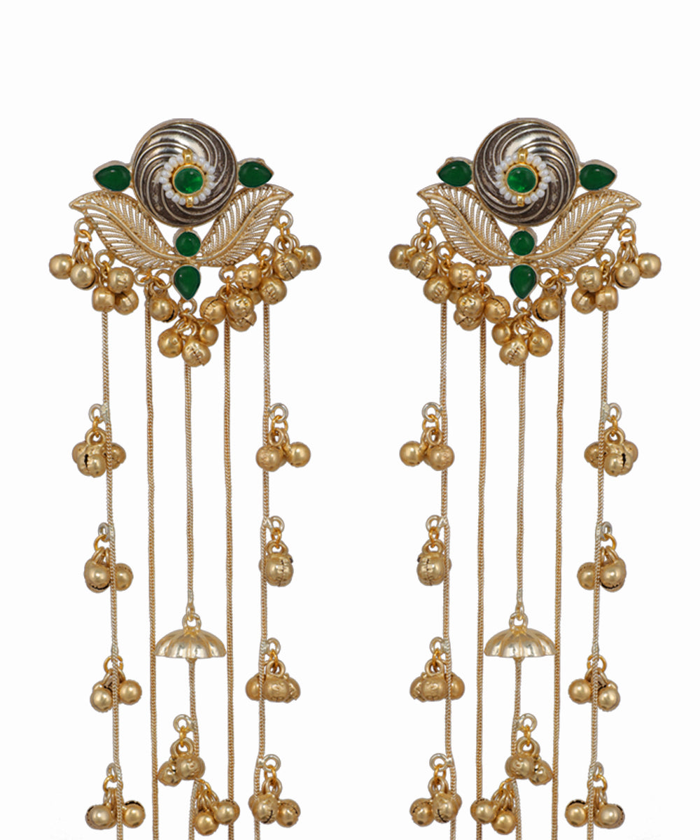 Pair of ornate earrings with gold and green accents on a white background