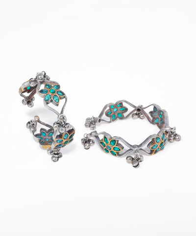 Pair of silver hoop earrings with turquoise gemstones on a white background