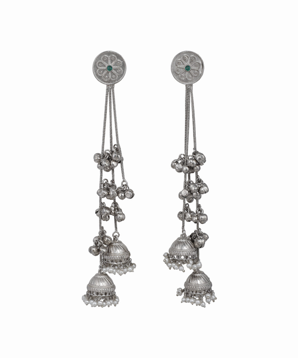 Pair of silver earrings with hanging components on a white background